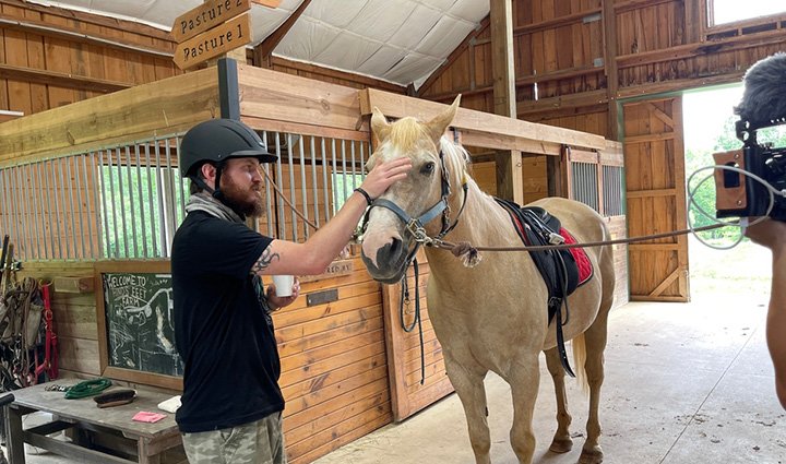 Wounded warrior Morgan Huss pets a horse during a session of equine therapy.