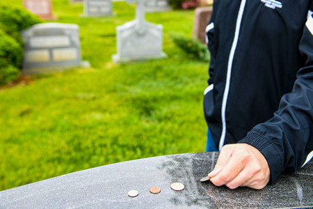 Warrior Placing Coins On Military Graves