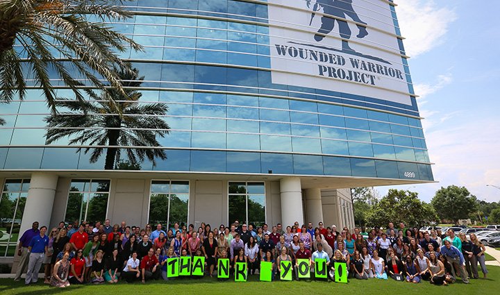 A group of supporters pose in front of Wounded Warrior Project’s headquarters with a big ‘Thank You’ sign.