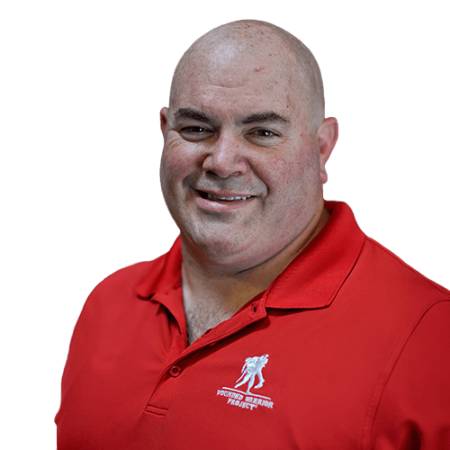 Warrior Bill Hansen smiling wearing a red Wounded Warrior Project polo.