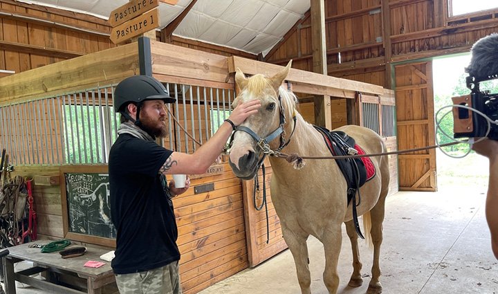 El veterano herido Morgan Huss acaricia un caballo durante una sesión de equinoterapia.