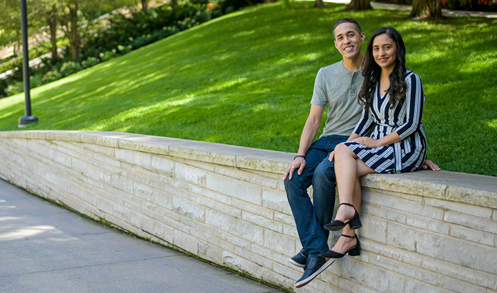 Wounded warrior Sergio Alfaro and wife Christina sitting outside on a stone wall.