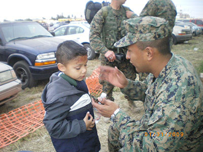 John Casares pains his stepson's face at a Marine event.
