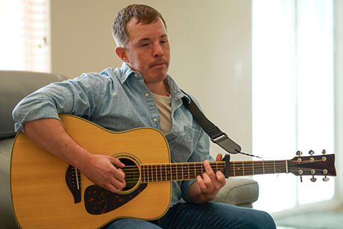 Marine Corps veteran Zach Tidwell playing the guitar.