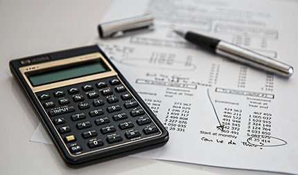 A calculator and budget paperwork.