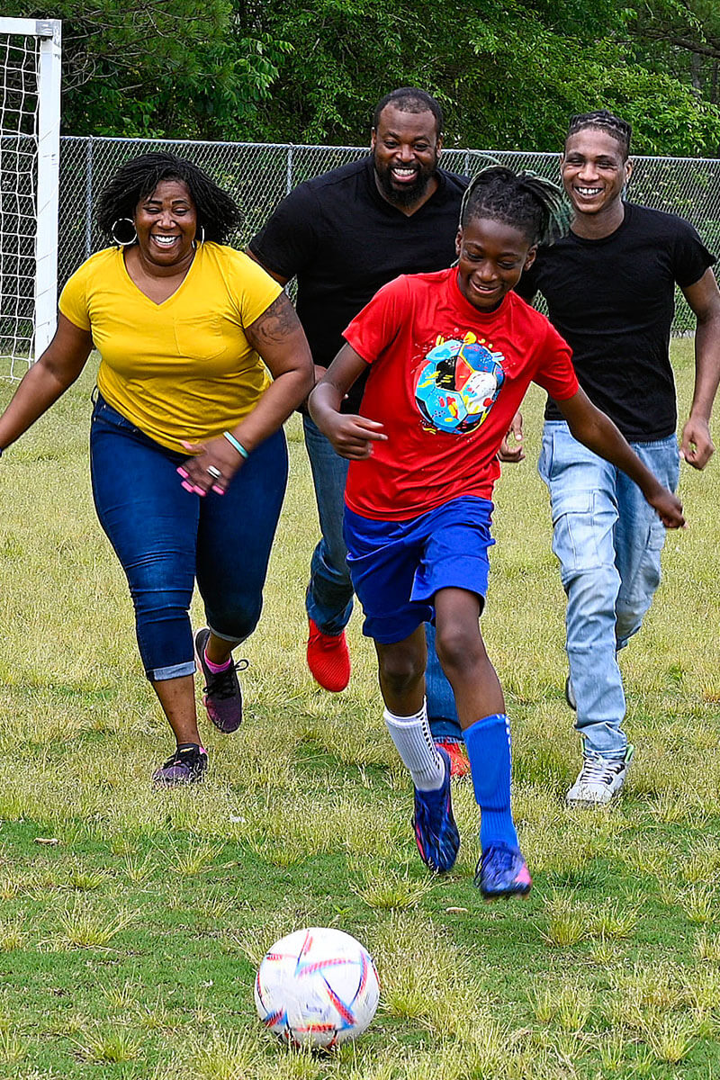 La veterana herida Taniki Richard se divierte jugando al fútbol con su familia.