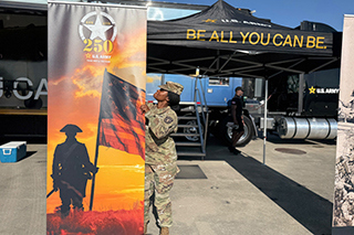 An Army sergeant sets up a display for the Army's 250th birthday at the Indy 500.
