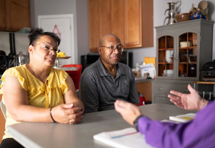 Wounded warrior Richard Daniel and his wife, Mina, sit at a table discussing their finances with a financial planner.