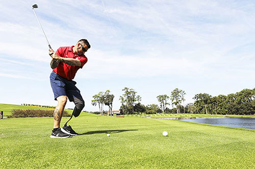 WWP warrior Sean Kapft hits a golf ball during a fundraising tournament.