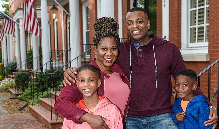 Wounded warrior Taniki Richards and her family hugging in a group photo outside of their house.