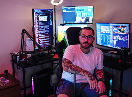 Army veteran Xander Hernandez playing video games on several consoles.