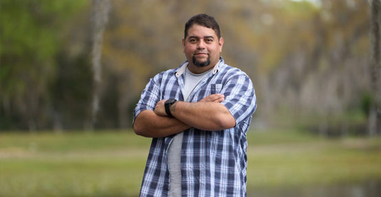 Tim Aponte, veterano herido, parado al aire libre.
