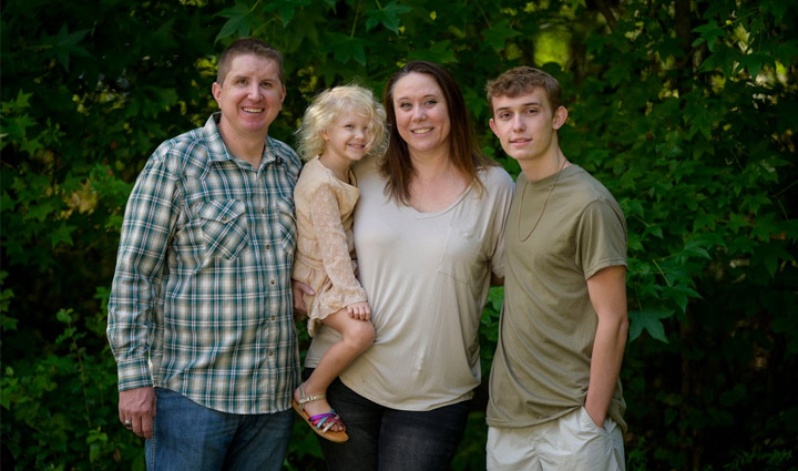 El veterano herido Bobby Woods está de pie afuera y posa para tomarse una fotografía con su esposa, Sarah, y sus hijos.