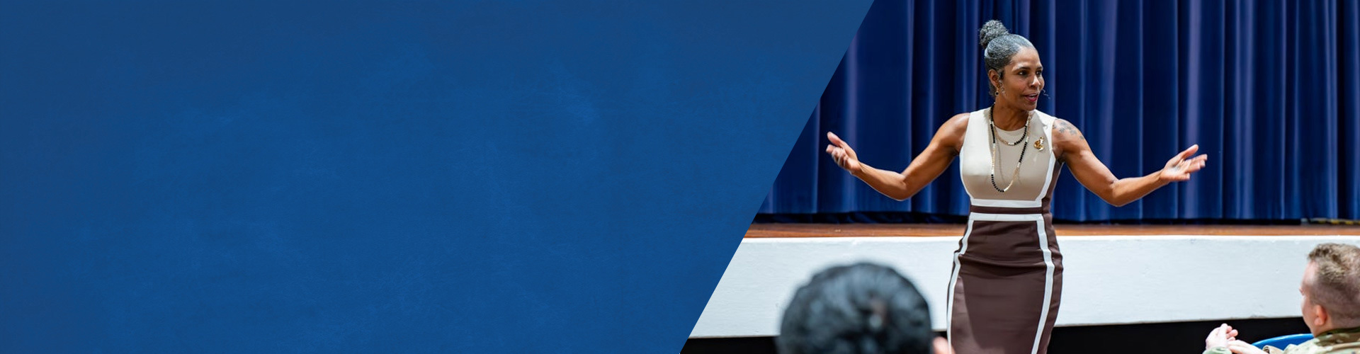 Wounded warrior Tonya Oxendine, dressed in business attire, speaks on stage at a Warriors Speak event.