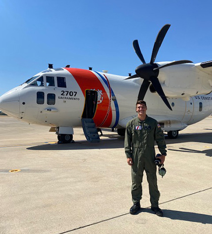 Coast Guard veteran Jake Prusha stands in front of a Coast Guard aircraft.