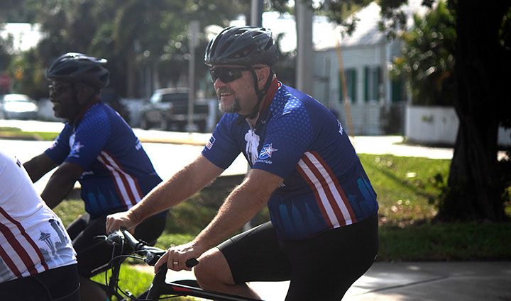 Un veterano herido anda en bicicleta mientras sonríe durante un evento de Soldier Ride.