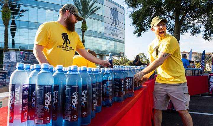Volunteers at Jacksonville's WWP Carry Forward 5K handing out AQUAhydrate water bottles to participants