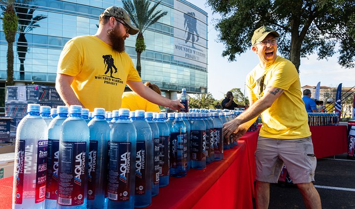 Voluntarios del WWP Carry Forward de 5 km de Jacksonville entregan botellas de agua AQUAhydrate a los participantes.