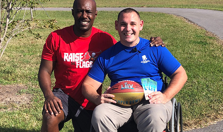 Wounded warrior Mike Delancey receiving Super Bowl tickets from NFL legend Dexter Jackson
