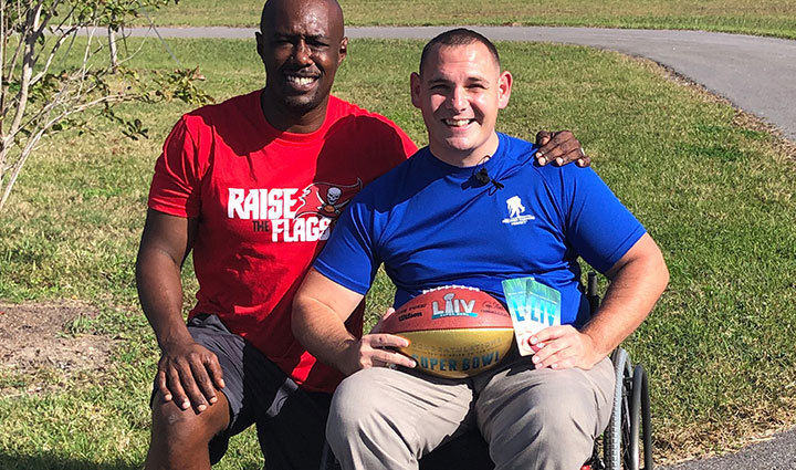 Warrior Mike Delancey receiving Super Bowl tickets from NFL legend Dexter Jackson