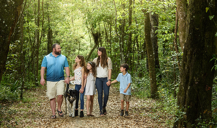 Caregiver Jenna Malone smiling and walking with her family.