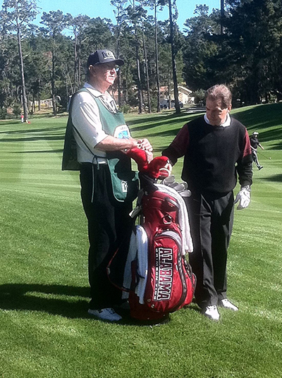 Golf caddie Wayne Beck caddying for former Alabama coach Nick Saban.