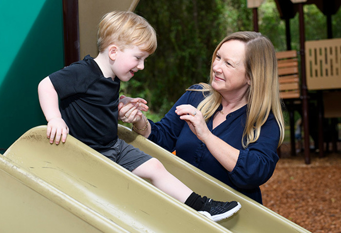 Family support member Jennifer Jenkins playing with her son on the playground.