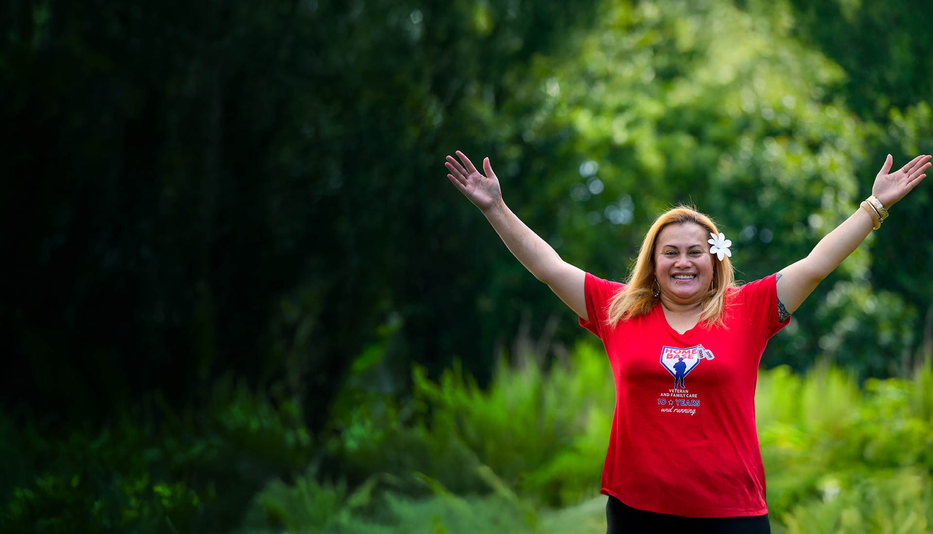 Wounded warrior Pele Hunkin smiles while raising her arms in a celebratory motion.