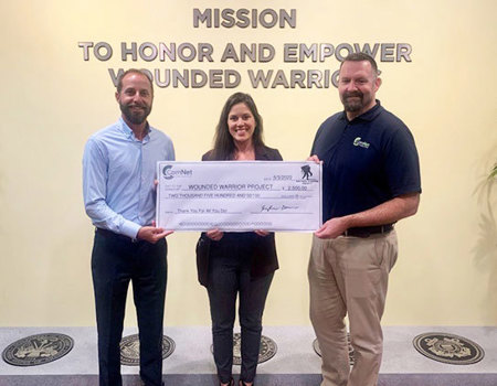 ComNet presenting a donation check to Wounded Warrior Project teammates
