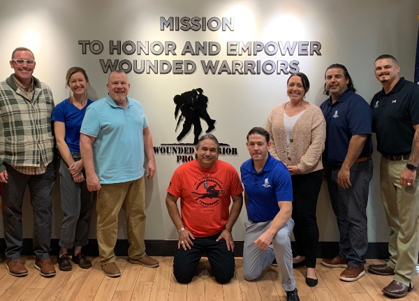 Tim Horton posing with group of warriors