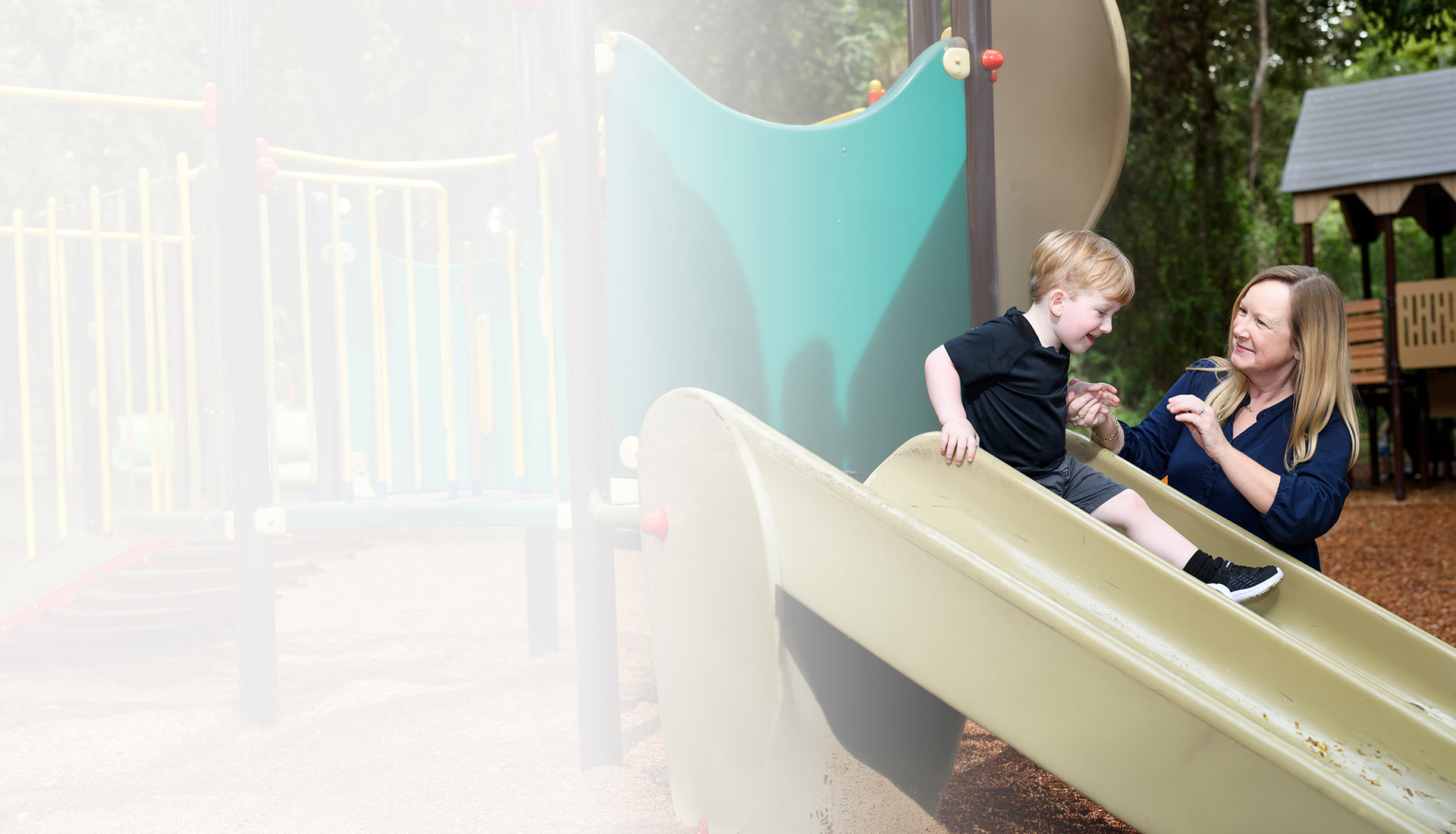 Family support member Jennifer Jenkins playing with her son on the playground.