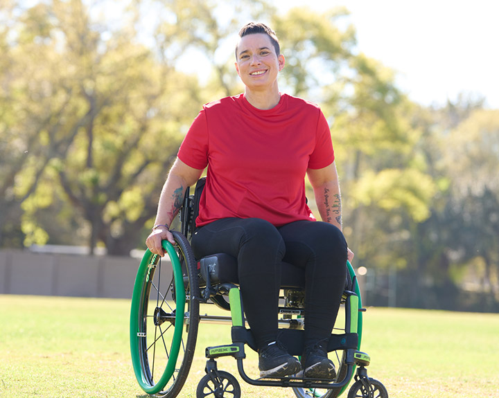 Beth King, veterana herida, en una silla de ruedas y sonriendo.