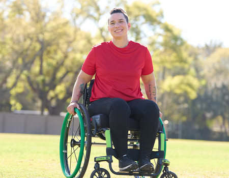 Wounded warrior Beth King sitting in a wheelchair smiling.