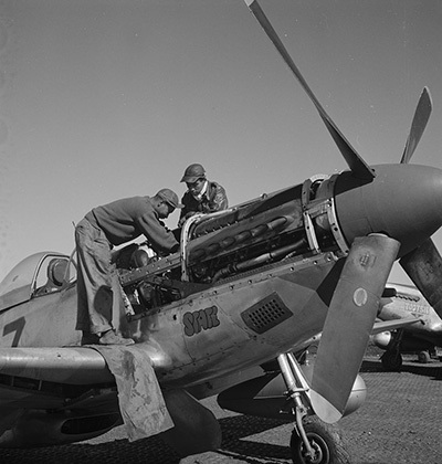 Tuskegee Airmen Marcellus G. Smith and Roscoe C. Brown work on a plane.