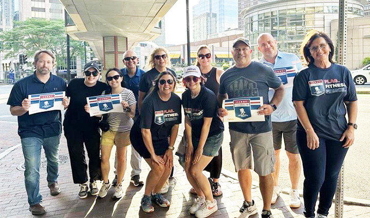 A group from the Optum Serve Volunteer Impact Racing Squad gathers for a group photo as they support runners during a virtual Carry Forward 5K.