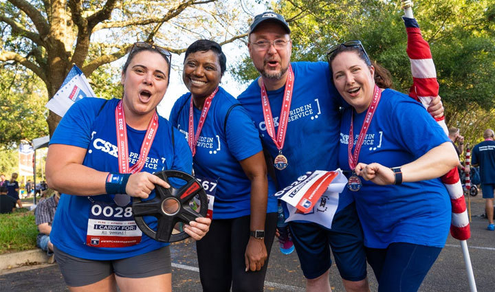 Participantes de Carry Forward 5K posando con sus medallas.