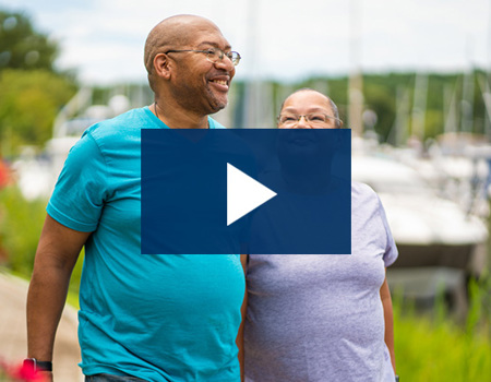Wounded warrior Richard Daniel and his wife and caregiver, Mina Daniel, smile while walking outside.