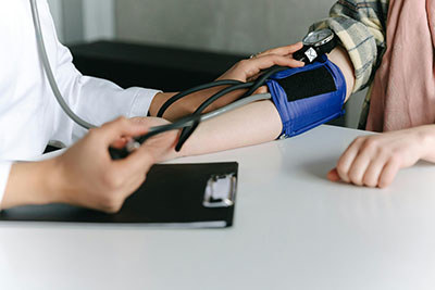 A doctor takes notes from a patient.