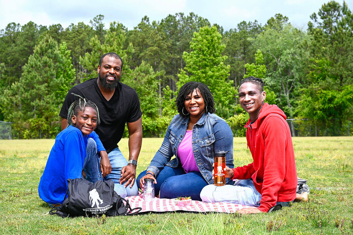 La veterana herida Taniki Richard y su familia haciendo un picnic al aire libre.