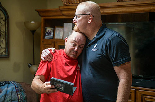 Marine Corps veterans Nick Bennett and Dan Miller hug recalling their shared time in Iraq.