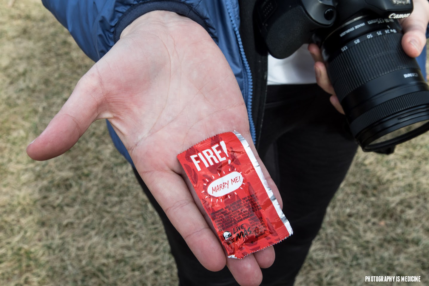 Frank Carr presents Army veteran Briana McCrae with a hot sauce packet that says, 