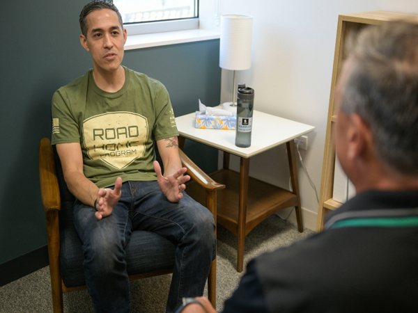 Warrior Sergio Alfaro attended Warrior Care Network's Road Home program at Rush University. He is talking to someone. 