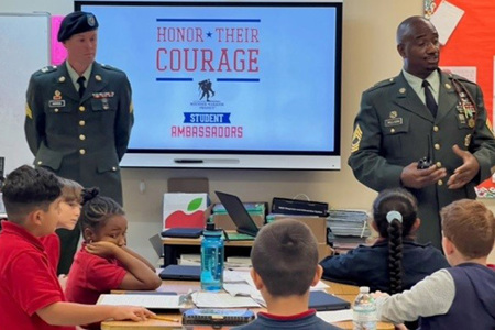 Service members speak to students in a classroom as part of WWP’s Honor Their Courage program.