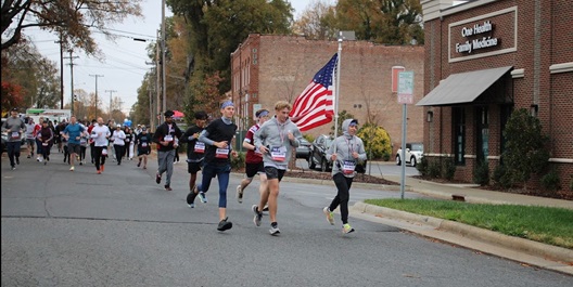 Participants in a 2023 Carry Forward 5K traverse the streets of Huntersville, NC to raise money for WWP.