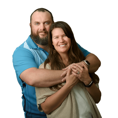 Warrior Issac Malone, stands with his wife and caregiver, Jenna, both smiling.