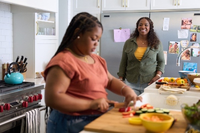 A mom and daughter in the kitchen connecting over food preparation.