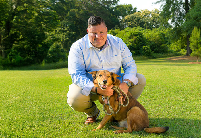 Wounded warrior Jake Narotsky poses with his dog in a park.