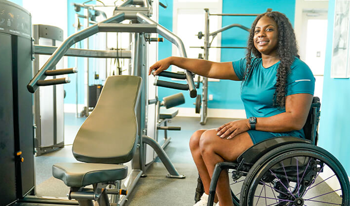 Wounded warrior Corine Hamilton sitting in a wheelchair at the gym.