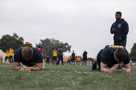 Two sailors do a plank during the Navy's physical readiness test.