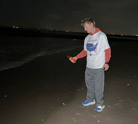 Runner Nels Matson stands by the ocean at night.